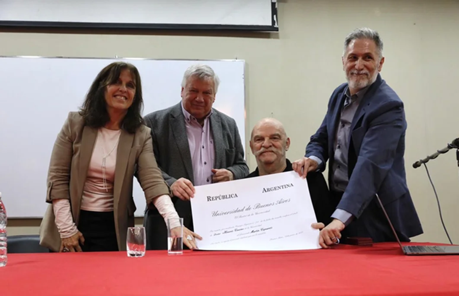 Un reconocimiento merecido La Universidad de Buenos Aires (UBA) otorgó al periodista y escritor Martín Caparrós el título de Doctor Honoris Causa, su máximo reconocimiento académico. La ceremonia se realizó en la Facultad de Filosofía y Letras. Se destacó su trayectoria en periodismo, literatura y cultura. La ceremonia El rector Ricardo Gelpi presidió el acto, acompañado por el decano Ricardo Manetti y la vicedecana Graciela Morgade. El escritor Daniel Guebel pronunció la laudatio. El evento, emotivo, reunió a figuras del ámbito académico y cultural en un aula colmada. Vínculo con la UBA Caparrós evocó su relación con la UBA, iniciada en 1968 con el examen de ingreso al Colegio Nacional. “Empezó, si mal no recuerdo, el 5 de diciembre de 1968, a las 9 de la mañana”, relató. También explicó por qué usa su segundo nombre: “Mi padre, Antonio, era conocido en la facultad. Elegí Martín para no aclarar que no era él”. Reflexión sobre la cultura Caparrós ofreció una mirada crítica sobre la cultura en Argentina. “Es difícil medir un éxito personal en una sociedad tan arruinada”, afirmó. Cuestionó el impacto de sus libros: “¿Qué son unos pocos libros en un país que lee cada vez menos?”. Sin embargo, resaltó el valor de la UBA: “Hace 50 años tenía 100.000 estudiantes y estaba intervenida. Hoy, con 300.000, es autónoma y entre las cien mejores del mundo”. Trayectoria destacada El Consejo Superior de la UBA reconoció a Caparrós por su aporte a la cultura, las letras y la comunicación. Con más de 40 libros publicados, traducidos a varios idiomas, ha recibido premios como el Konex (2004 y 2024), el Konex de Platino (2014), el Ortega y Gasset, el Ítaca de la Universidad Autónoma de Barcelona y el Archiletras de la Lengua.